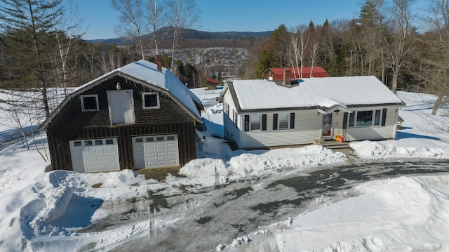 view of front facade with board and batten siding, a chimney, and a garage