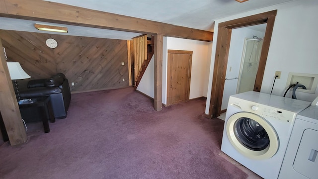 washroom with washing machine and clothes dryer, dark carpet, wood walls, laundry area, and baseboards