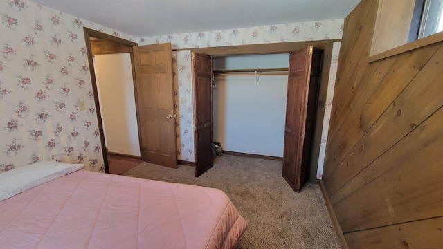 bedroom with carpet floors, a closet, baseboards, and wallpapered walls