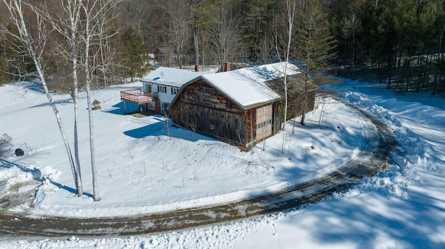 snowy aerial view featuring a forest view