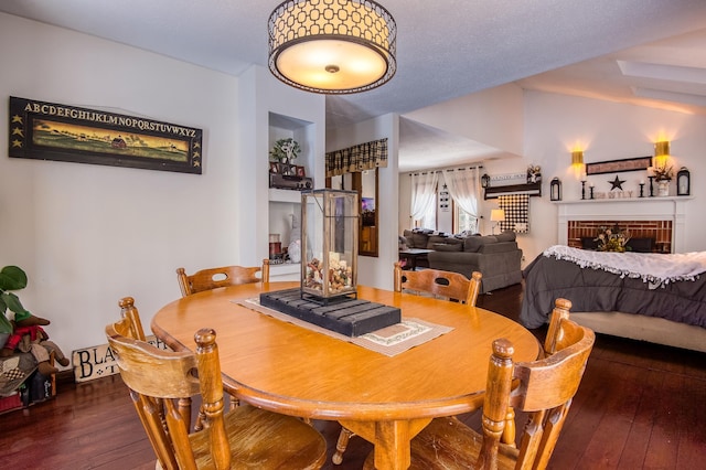 dining room with wood-type flooring and a fireplace