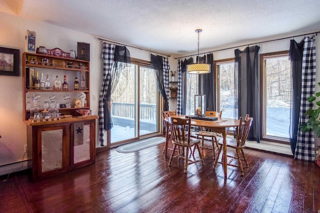 dining room featuring wood-type flooring and a textured ceiling