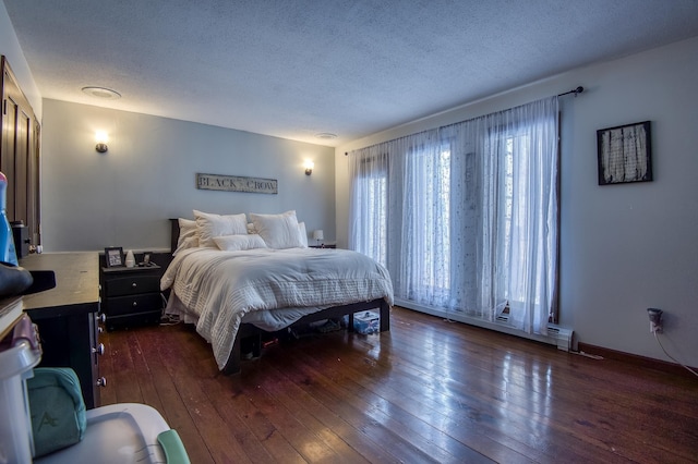 bedroom with dark wood-type flooring, a textured ceiling, and baseboards