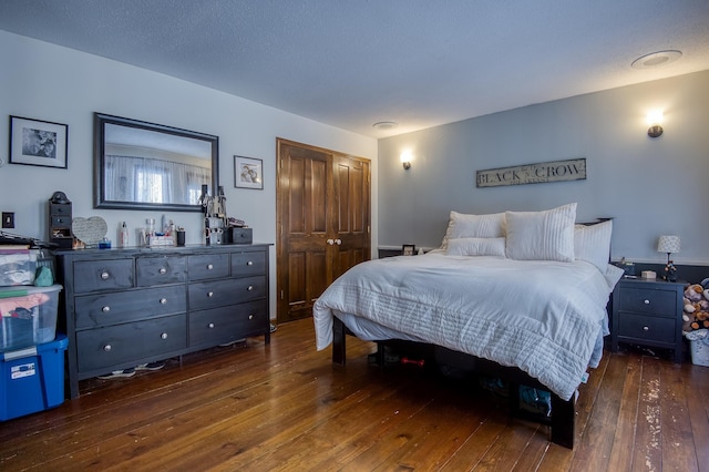 bedroom featuring a textured ceiling, a closet, and dark wood-type flooring