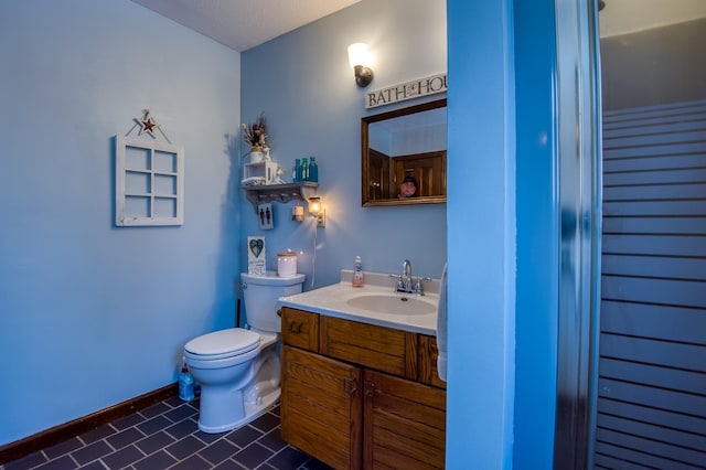 bathroom featuring vanity, toilet, and baseboards