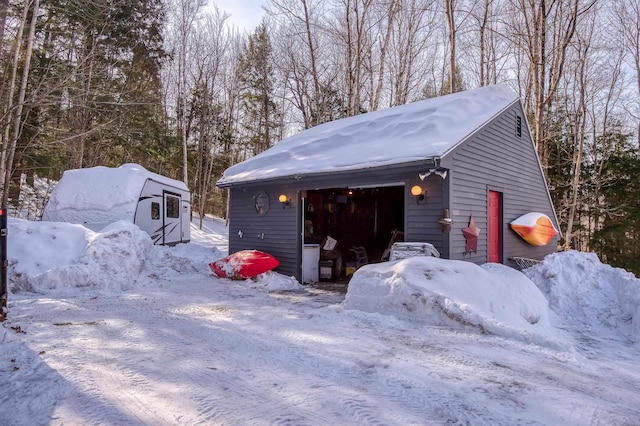 snow covered garage featuring a detached garage