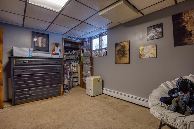 rec room featuring a baseboard radiator, carpet flooring, and a paneled ceiling