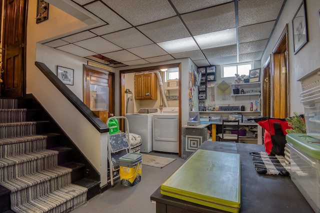 below grade area featuring stairs, a drop ceiling, and independent washer and dryer