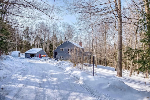 yard covered in snow with a garage and an outdoor structure