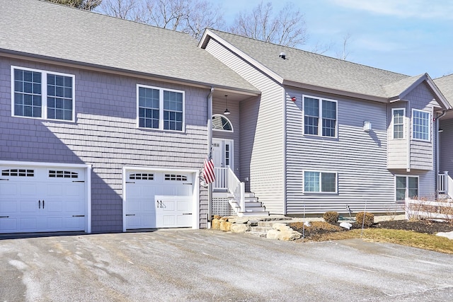 bi-level home featuring driveway, a shingled roof, and an attached garage