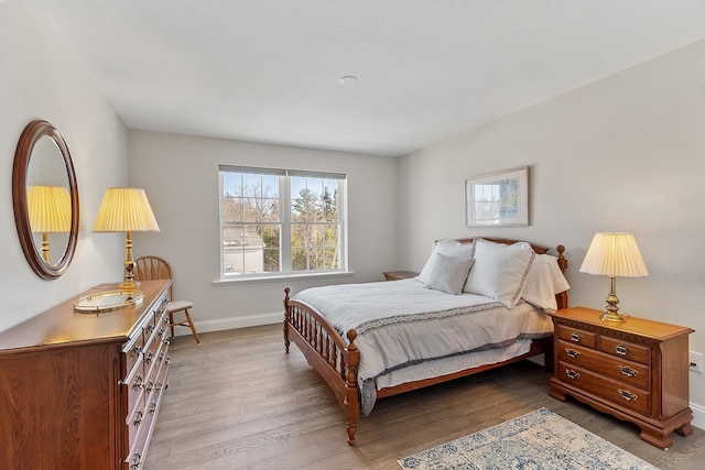 bedroom with baseboards and wood finished floors