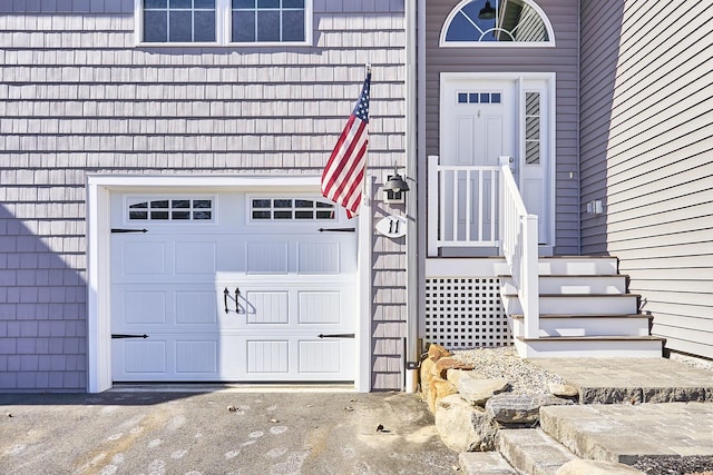 doorway to property with a garage and driveway