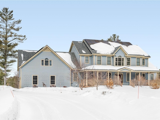 view of front facade with covered porch and roof mounted solar panels