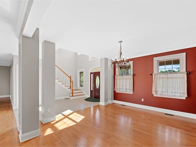 foyer entrance with light wood-type flooring, stairway, plenty of natural light, and visible vents