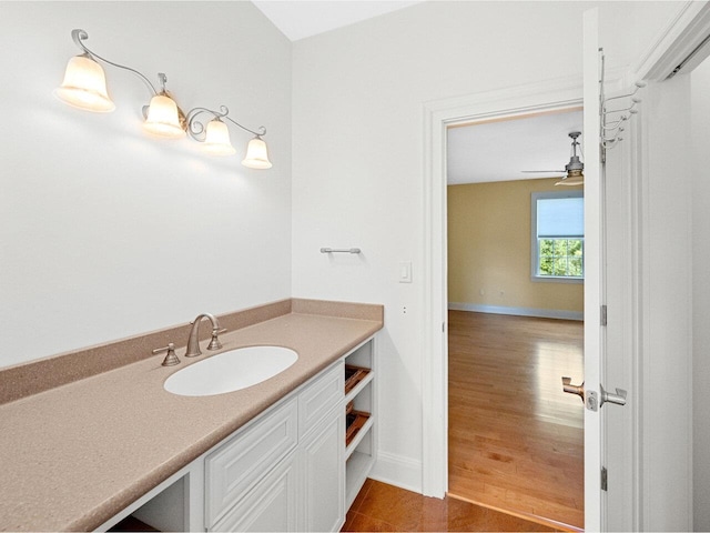 bathroom with ceiling fan, wood finished floors, vanity, and baseboards