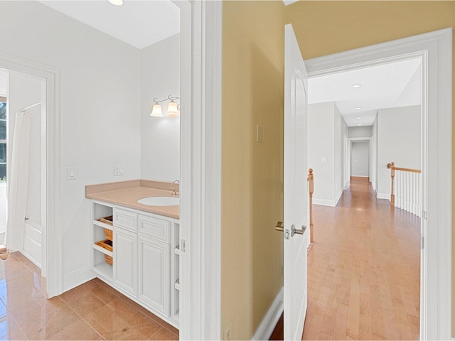 bathroom with recessed lighting, wood finished floors, vanity, and baseboards