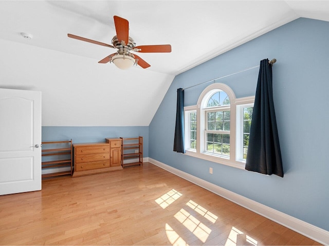 bonus room with light wood-style floors, vaulted ceiling, baseboards, and a ceiling fan