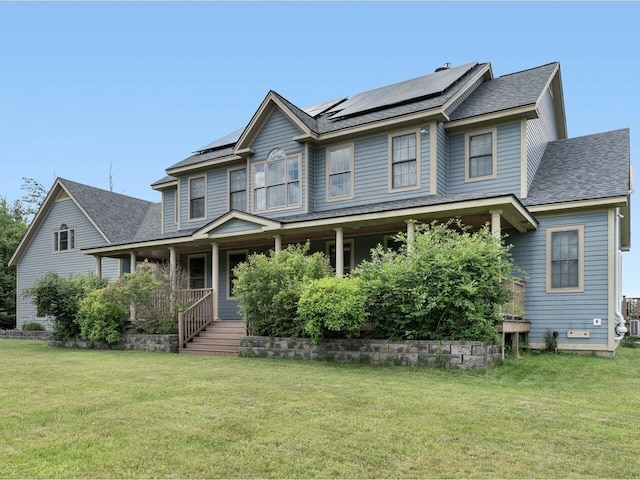 view of front of home with covered porch, a front lawn, and solar panels