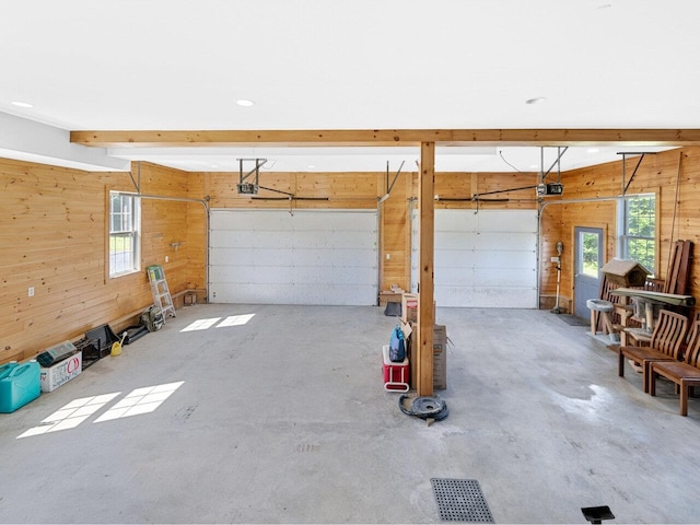 garage with wood walls and a garage door opener