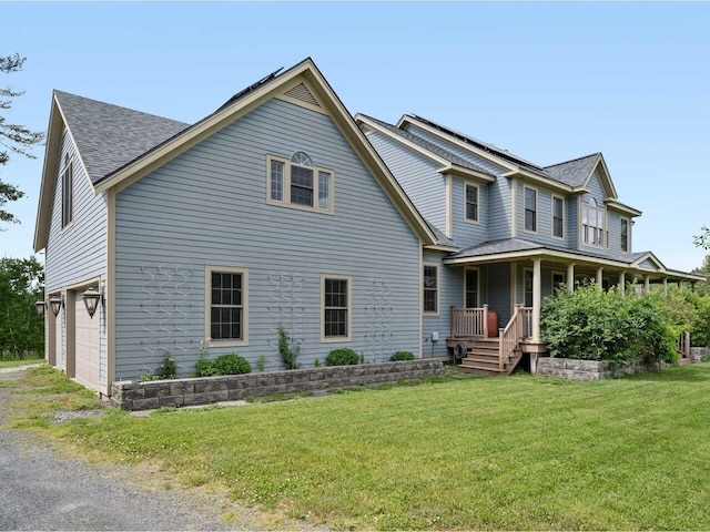 view of front facade with covered porch, a front lawn, and a shingled roof