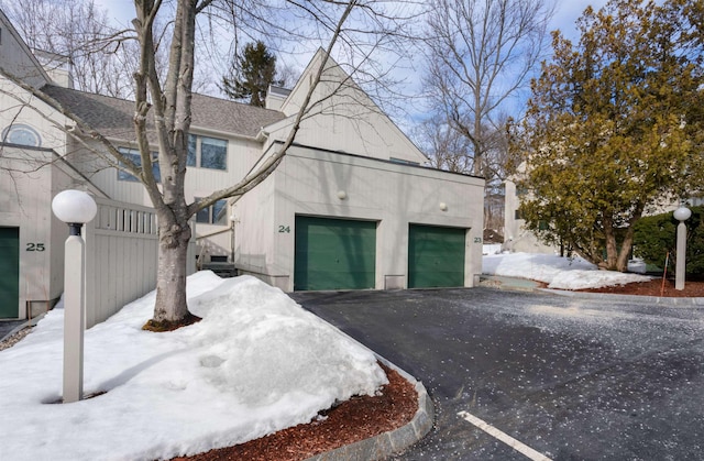 view of front of house featuring driveway and roof with shingles