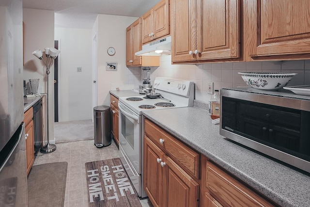 kitchen with white range with electric cooktop, light countertops, stainless steel microwave, decorative backsplash, and under cabinet range hood