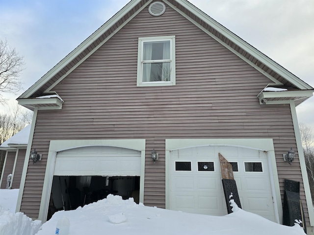 snow covered property featuring a garage