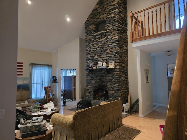 96 Mason Dr, Milan, NH 03588 - living area with high vaulted ceiling, a stone fireplace, baseboards, and wood finished floors