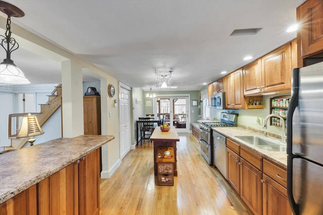 kitchen with a sink, light wood-type flooring, brown cabinets, stainless steel appliances, and open shelves