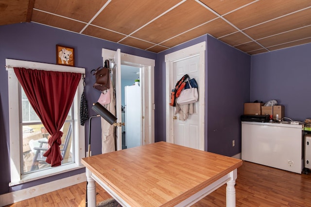 dining area with a drop ceiling and wood finished floors