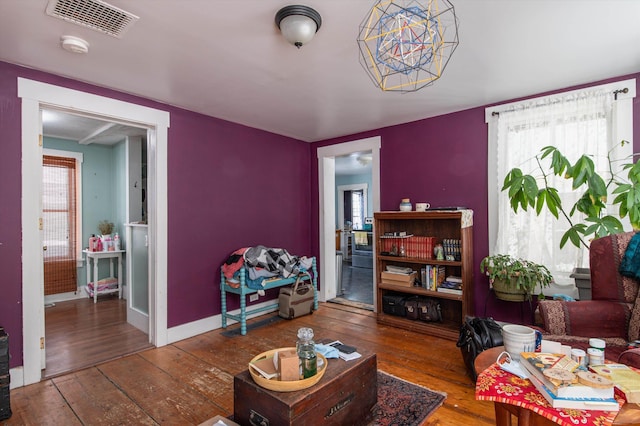 living room featuring visible vents, plenty of natural light, and hardwood / wood-style flooring