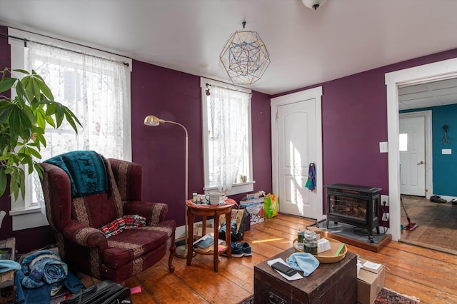 living area featuring a wood stove, plenty of natural light, and hardwood / wood-style floors