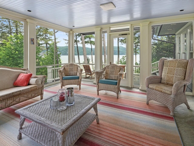 sunroom / solarium featuring a water view, wooden ceiling, and a healthy amount of sunlight