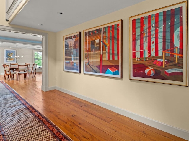 hallway featuring hardwood / wood-style flooring and baseboards