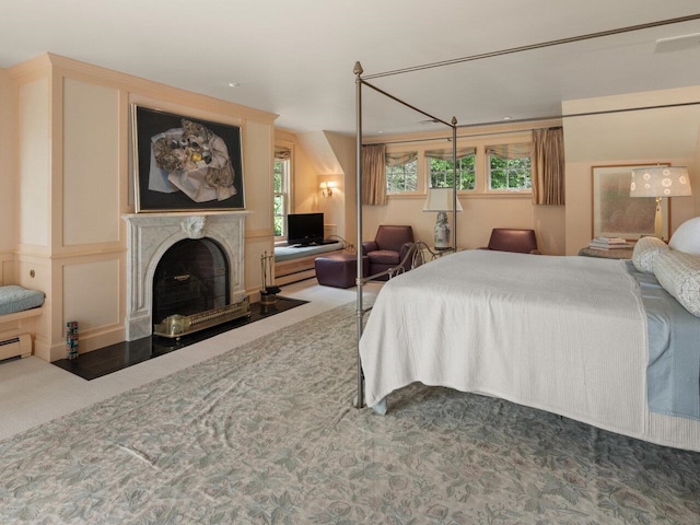 carpeted bedroom with a high end fireplace