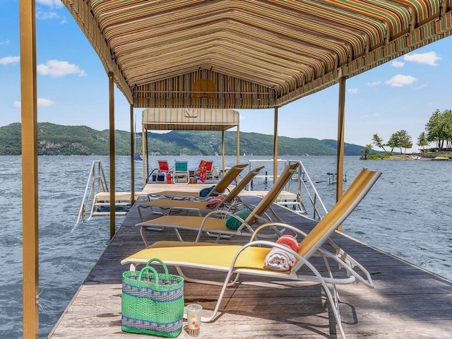 view of dock featuring boat lift and a water and mountain view