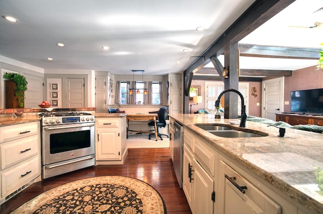 kitchen with dark wood-style flooring, recessed lighting, appliances with stainless steel finishes, a sink, and light stone countertops