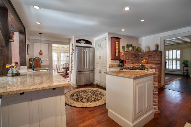 kitchen with stainless steel appliances, a healthy amount of sunlight, a sink, and dark wood-type flooring