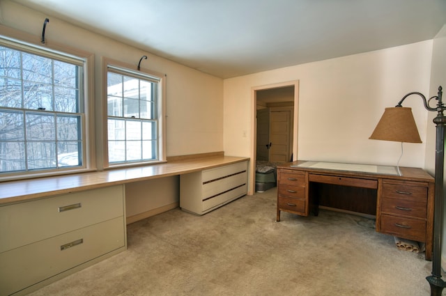 home office with built in desk and light colored carpet