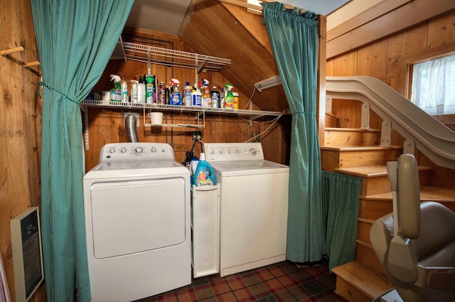 clothes washing area with washing machine and dryer, laundry area, and wooden walls