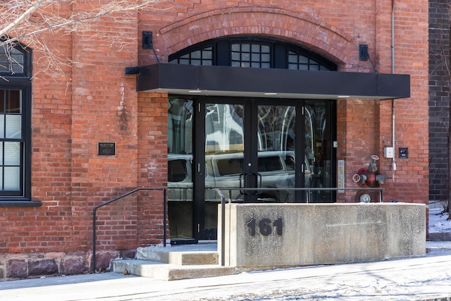 doorway to property with brick siding