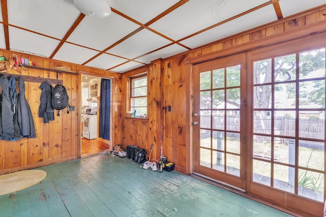 doorway featuring wood-type flooring and wooden walls