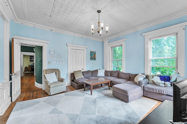 living area featuring a chandelier, crown molding, and wood finished floors