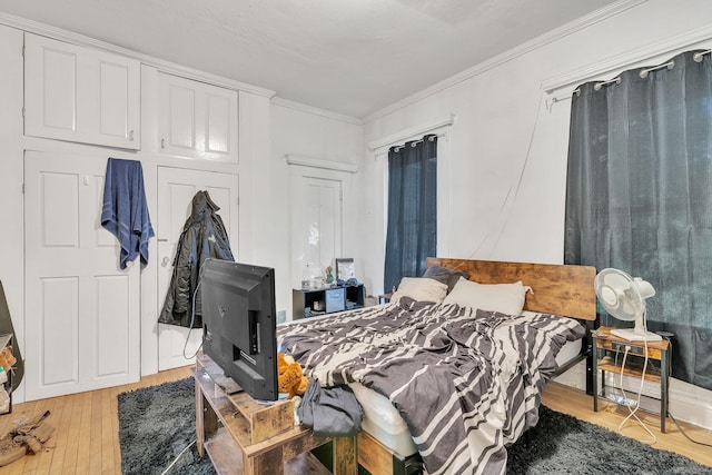 bedroom with ornamental molding and hardwood / wood-style floors