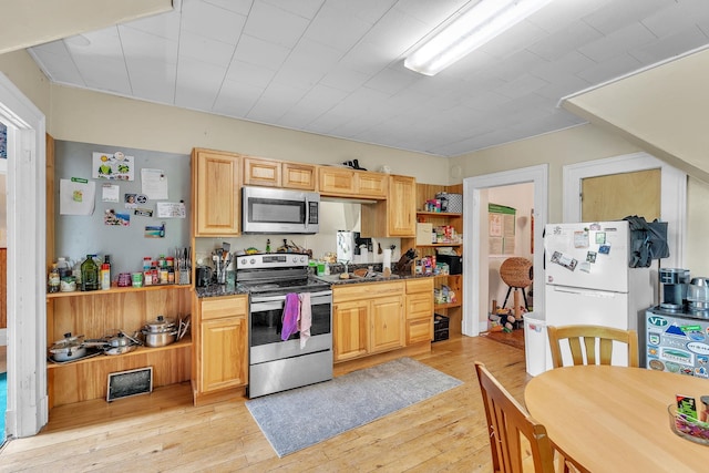 kitchen featuring stainless steel appliances, light brown cabinets, light wood-style floors, and open shelves