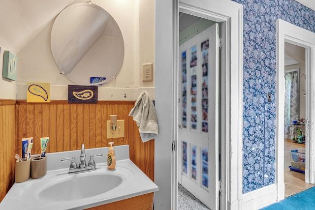 bathroom featuring wainscoting, vanity, and wallpapered walls