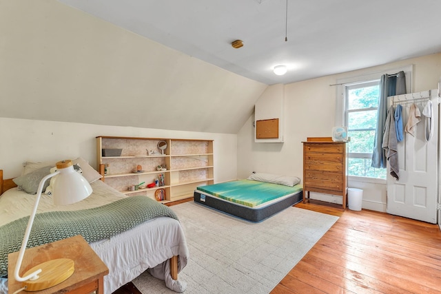 bedroom featuring light wood-style floors and lofted ceiling