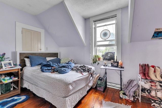 bedroom with lofted ceiling and wood finished floors