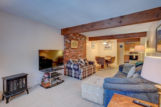 living room with a textured ceiling, beamed ceiling, carpet, and a ceiling fan