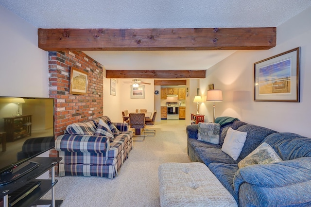 living area featuring a textured ceiling, carpet flooring, beam ceiling, and a ceiling fan